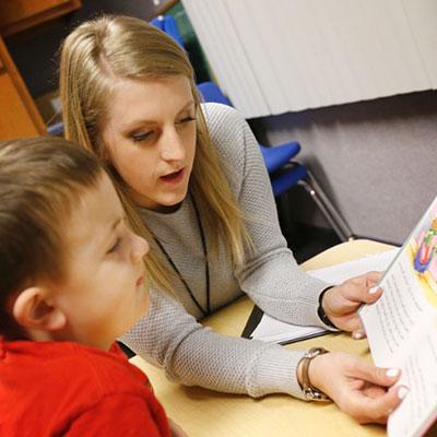 Student reading to child